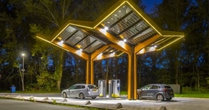 Picture of two electric vehicles charging at night time.