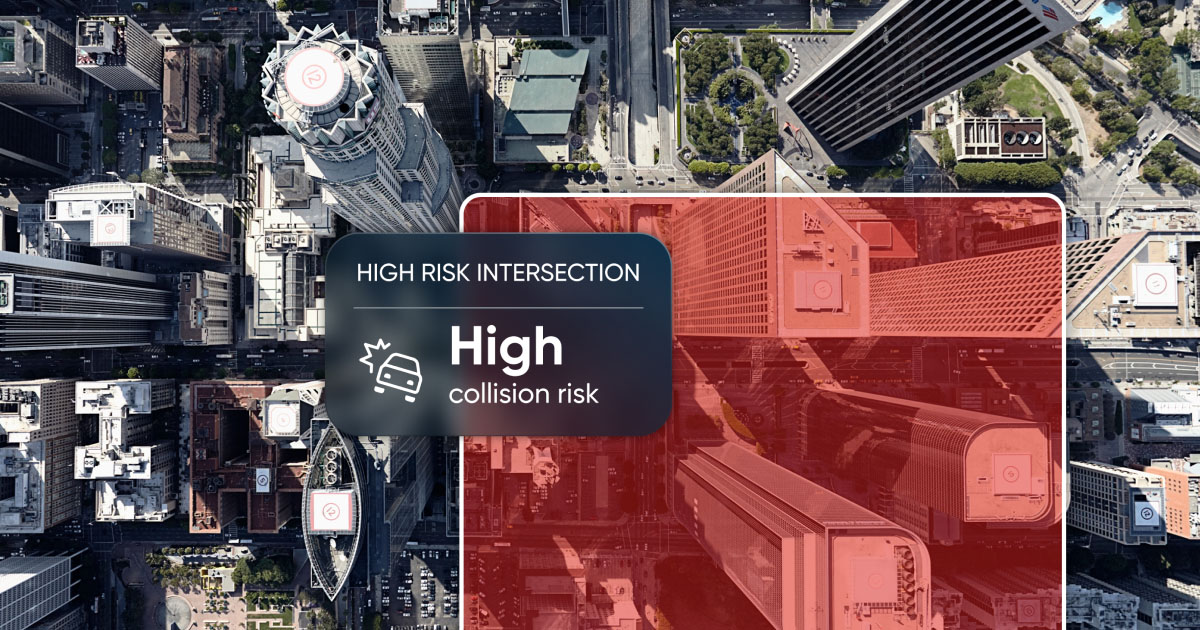 Aerial view of a city intersection marked by a warning overlay indicating "High collision risk" at a high-risk intersection, with the TomTom logo prominently displayed.