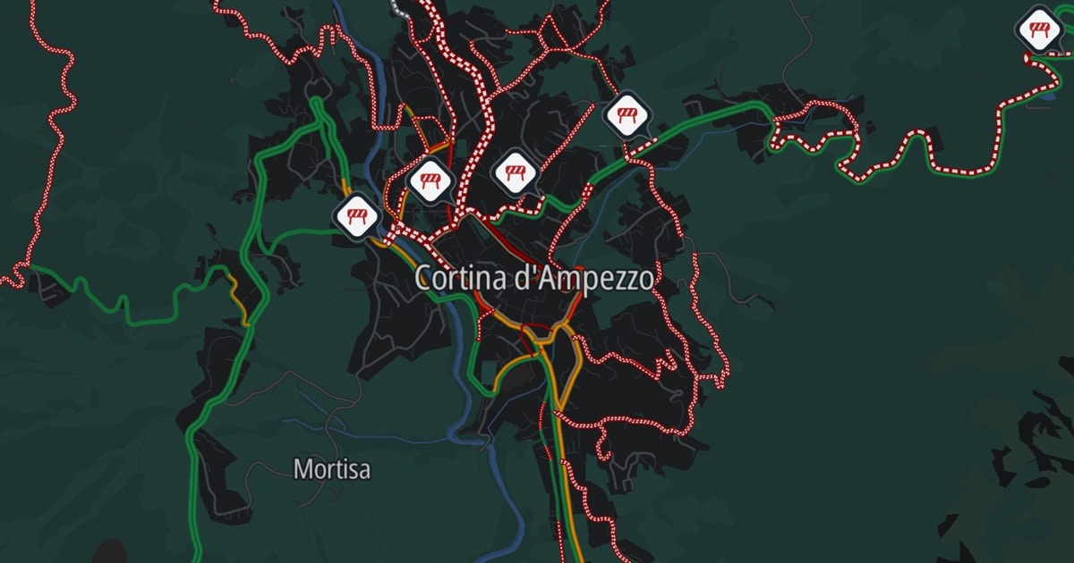 Map highlighting Cortina d'Ampezzo, with red, green, and orange routes and icons indicating mountain locations.