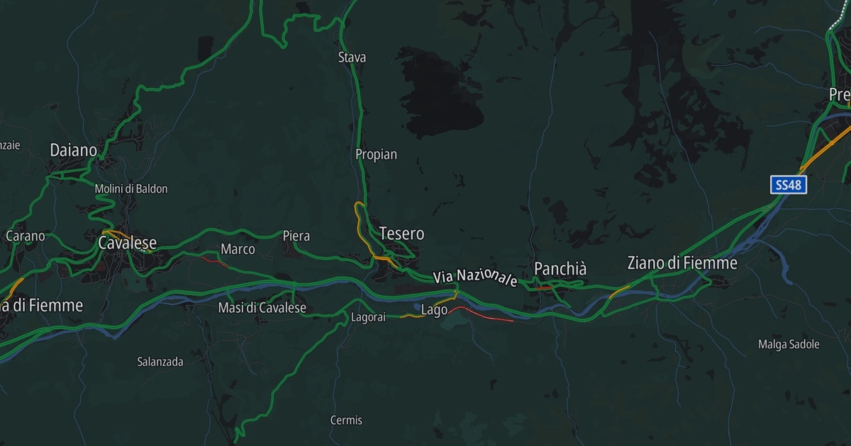 Dark map showing areas in Italy including Tesero, Cavalese, and Ziano di Fiemme, with roads and geographic details highlighted in bright colors.