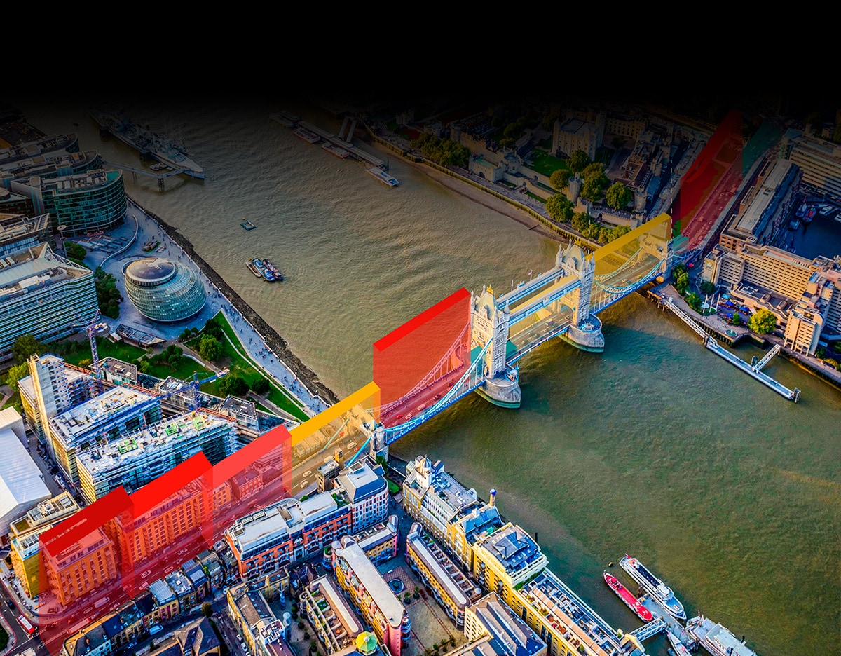 Aerial view of Tower Bridge in London with colorful red and yellow overlays highlighting surrounding buildings and the Thames River.