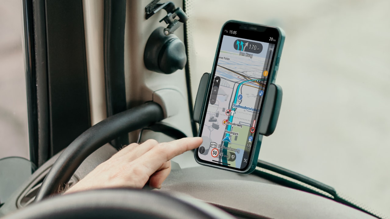 A person uses GO Expert app on a smartphone mounted in a car, showing a map and route directions.
