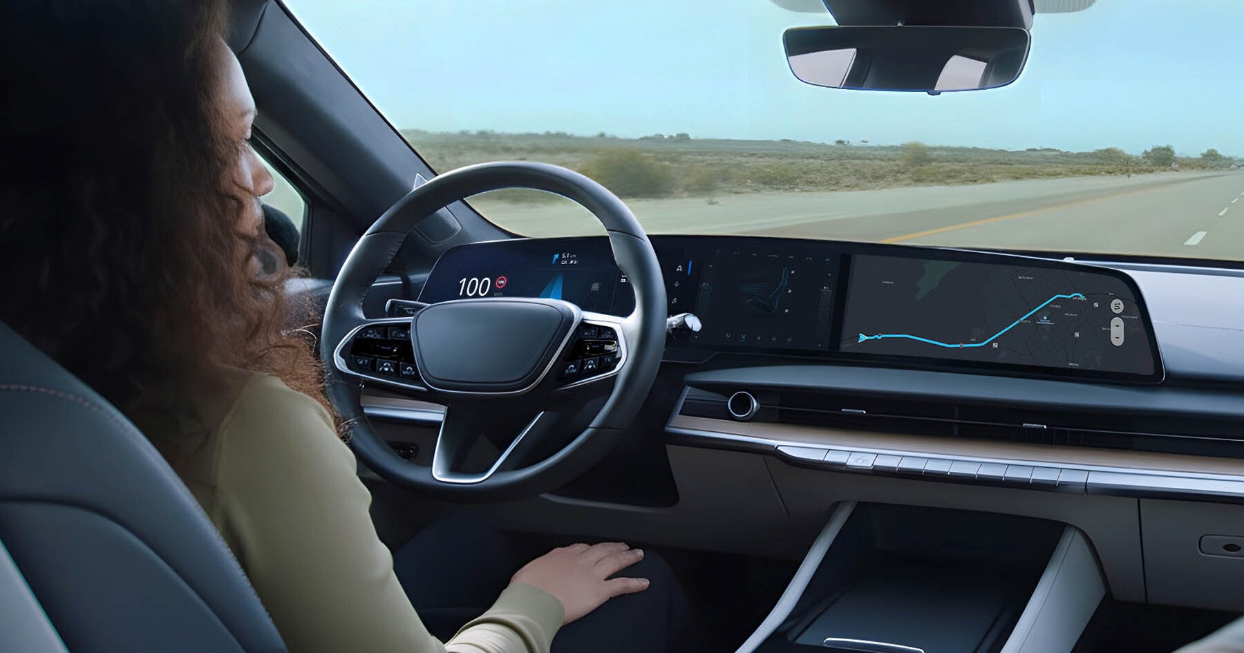 A person sits in a modern car with digital dashboard displays, showing speed and GPS navigation, driving on an open road.