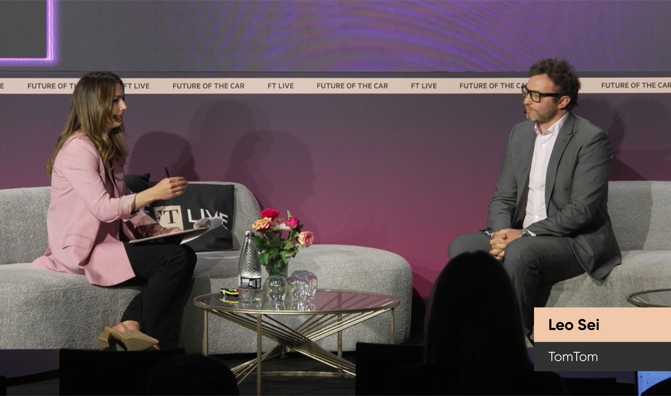 An interviewer and TomTom's CPO on stage at a "Future of the Car" event.